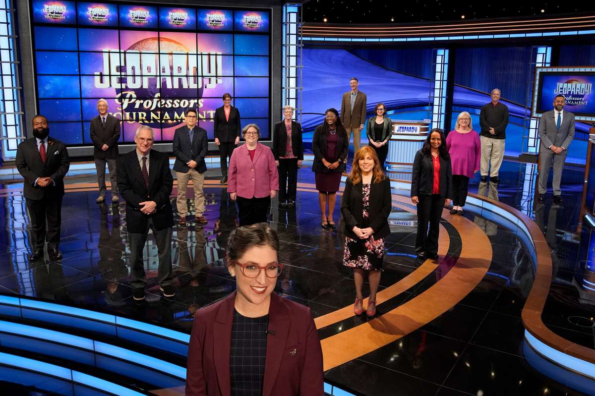 El profesor de la USF, JP Allen, al fondo, fotografiado con el anfitrión de Jeopardy, Mayim Bialik, en primer plano, y otros competidores durante el Torneo de Profesores de Jeopardy.