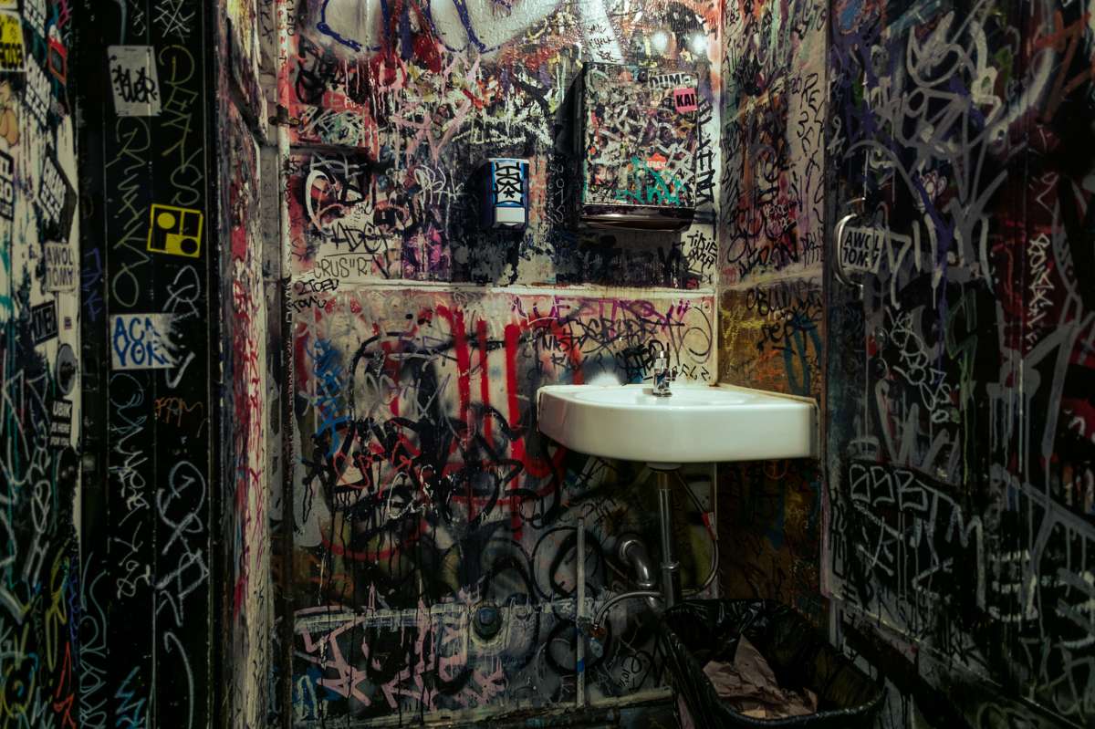 El baño de hombres en Delirium está lleno de cultura del graffiti y más allá. 