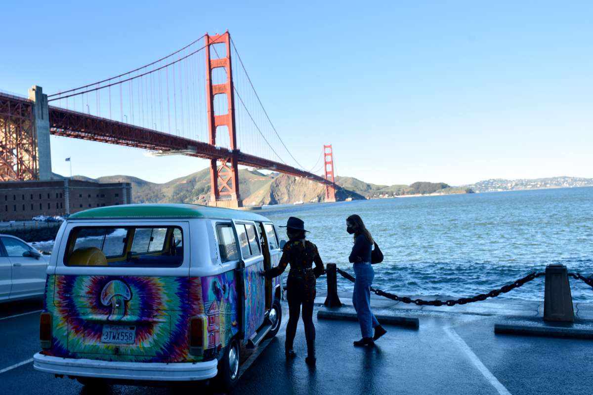 La guía turística Judith Berndsen abre la puerta lateral del Volkswagen Bus de San Francisco Love Tours para la reportera de SFGATE Madeline Wells cerca de Fort Point. 