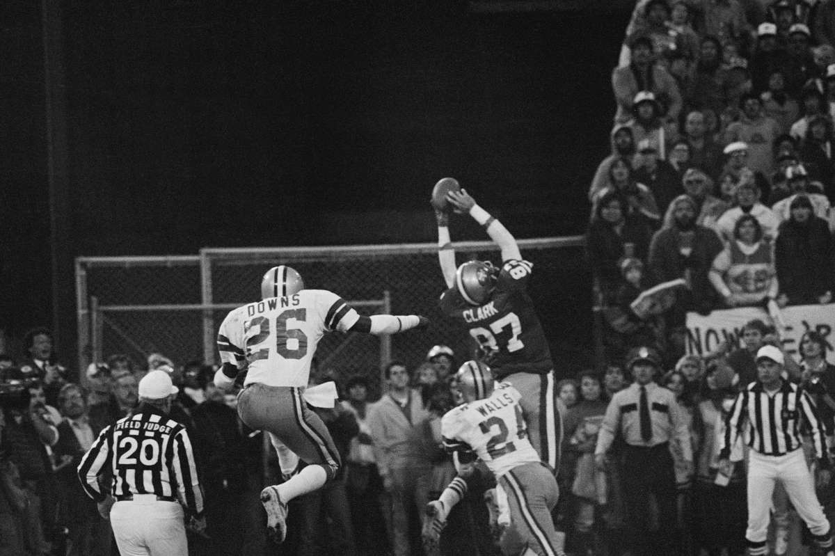 San Francisco 49ers Dwight Clark se eleva en el aire en la zona de anotación para el pase de touchdown que empató el juego de Joe Montana, conocido como "The Catch", que derrotaría a los Dallas Cowboys en el Juego de Campeonato de la NFC de 1981.