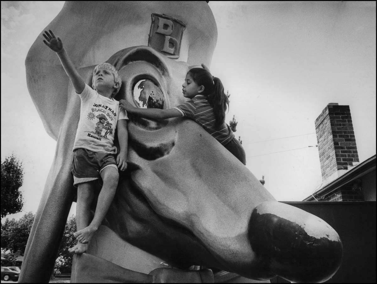 Dos niños pequeños se suben a una mascota de fibra de vidrio afuera de un restaurante Doggie Diner en Hayward en 1985. 