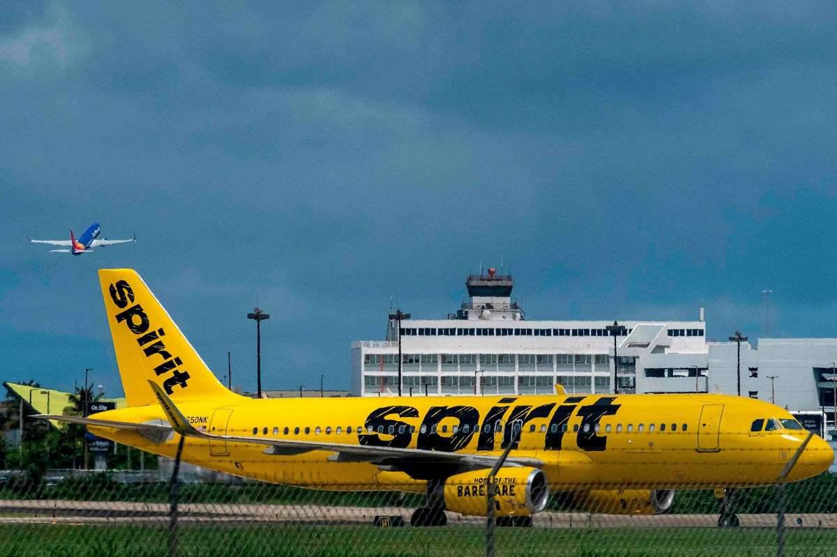 Se ve un avión comercial de Spirit Airlines sobre la pista mientras otro despega del Aeropuerto Internacional Luis Muñoz Marín en San Juan, Puerto Rico, el 18 de marzo de 2020.
