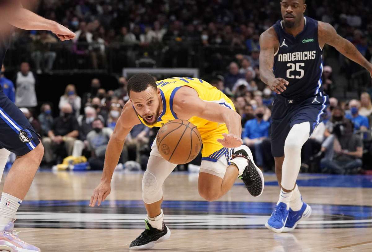 El escolta de los Golden State Warriors Stephen Curry (30) persigue el balón frente al alero de los Dallas Mavericks Reggie Bullock (25) durante la segunda mitad de un juego de baloncesto de la NBA en Dallas, el miércoles 5 de enero de 2022.