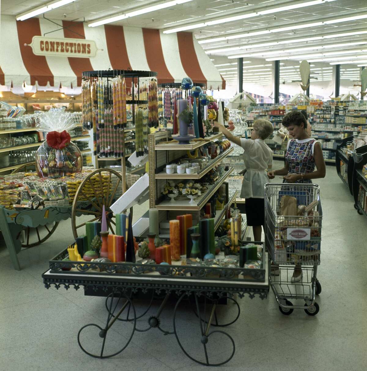 Una vista de los compradores mientras miran las velas en un carrito de exhibición en un supermercado Piggly Wiggly recién inaugurado en Encino, California, 1962.