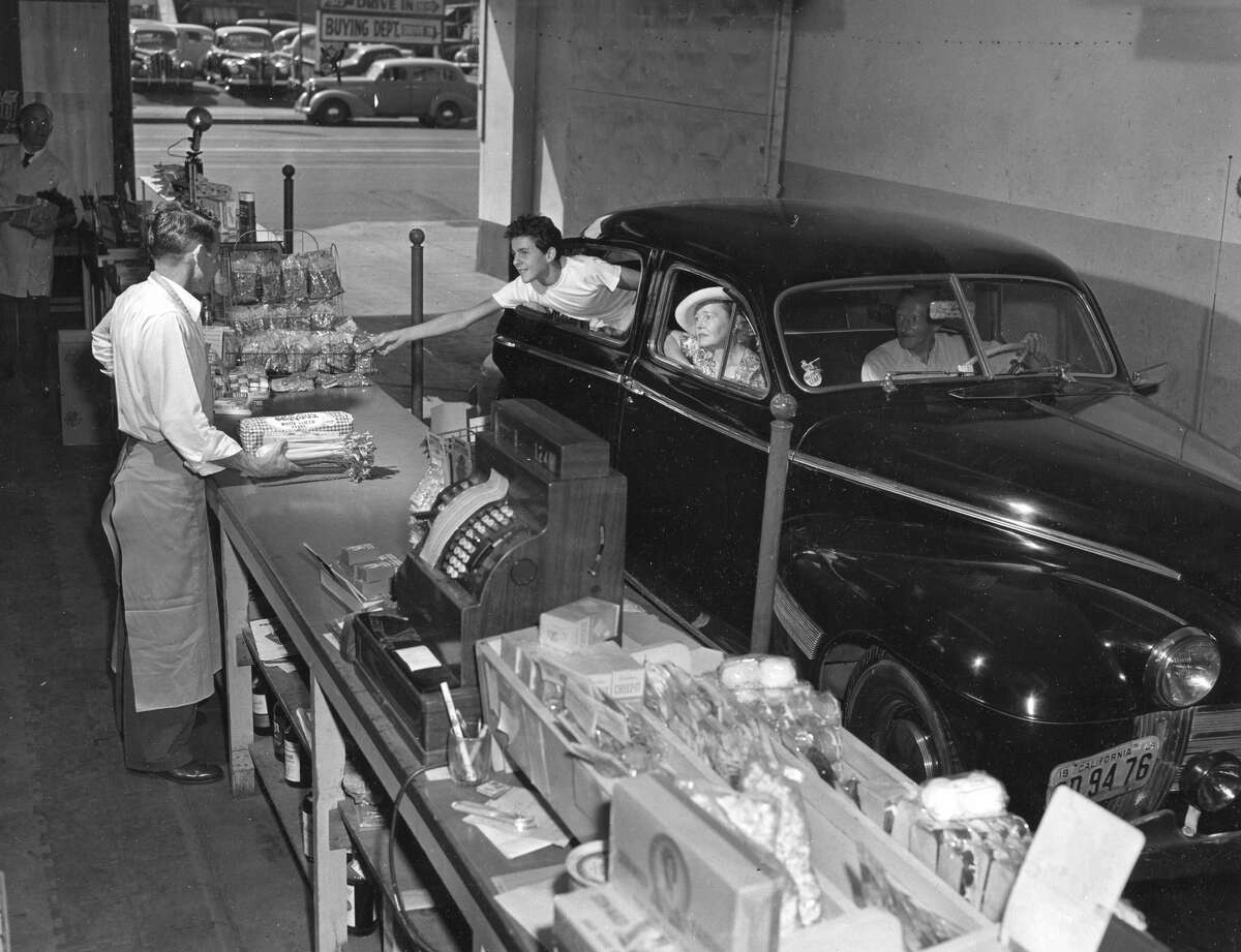 Clientes que compran pan y refrigerios en un mercado de autoservicio y licorería en Los Ángeles en 1949.