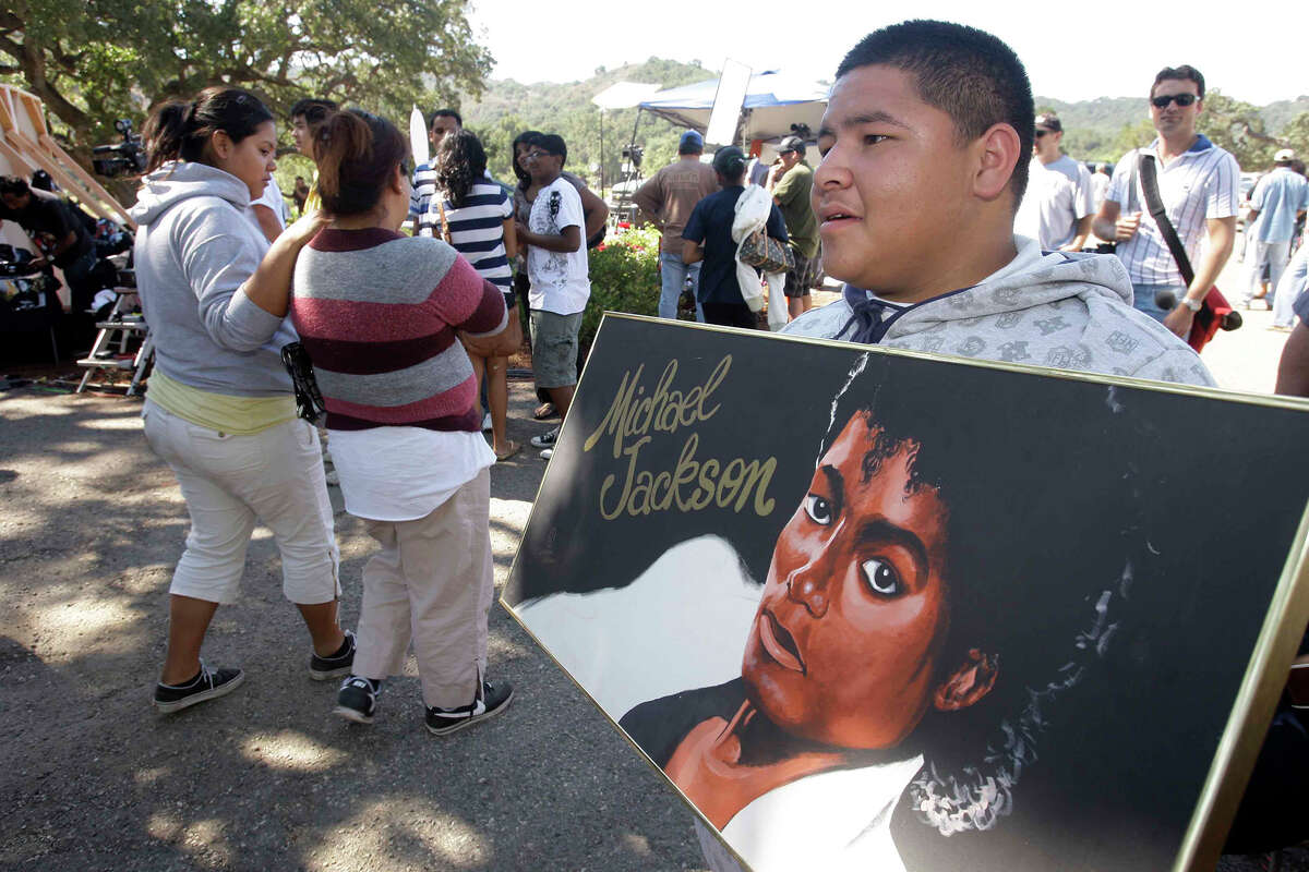 Luis Aldama, de 17 años, de Salinas, California, sostiene un retrato de Michael Jackson cerca de las puertas de la antigua residencia del difunto Michael Jackson, Neverland Ranch, en Los Olivos, California, el viernes 3 de julio de 2009. 