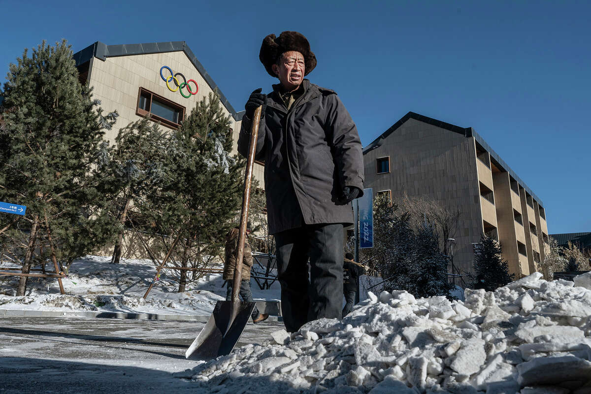 Un trabajador hace una pausa mientras quita nieve artificial de una carretera dentro de una de las villas de atletas para los Juegos Olímpicos de Invierno de Beijing 2022 antes de que se cerrara el área el 3 de enero en el condado de Chongli, Zhangjiakou, provincia de Hebei, norte de China. El área, que albergará eventos de esquí y snowboard durante los Juegos Olímpicos y Paralímpicos de Invierno, fue cerrada a todos los turistas y visitantes a partir del 4 de enero y será parte de la burbuja debido a la pandemia de coronavirus para los atletas, periodistas y funcionarios que participen. en los Juegos. 