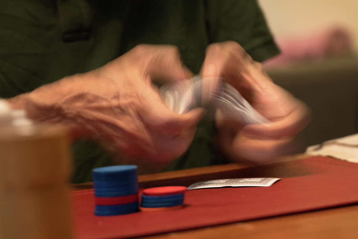 JP Massar baraja una baraja de cartas durante un juego de Texas Hold'em en su casa en Berkeley, California, el 13 de diciembre de 2021.