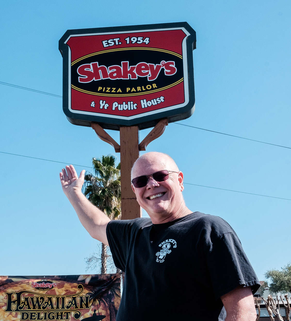 Dan Harvey, propietario desde hace mucho tiempo de Shakey's Pizza en Oroville, muestra el letrero del restaurante que se encuentra sobre el estacionamiento.