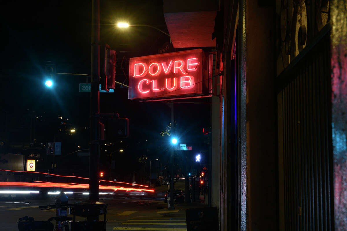 El letrero de neón del Dovre Club brilla de noche sobre la entrada del bar, en la intersección de Valencia y la calle 26 en San Francisco el 15 de marzo.