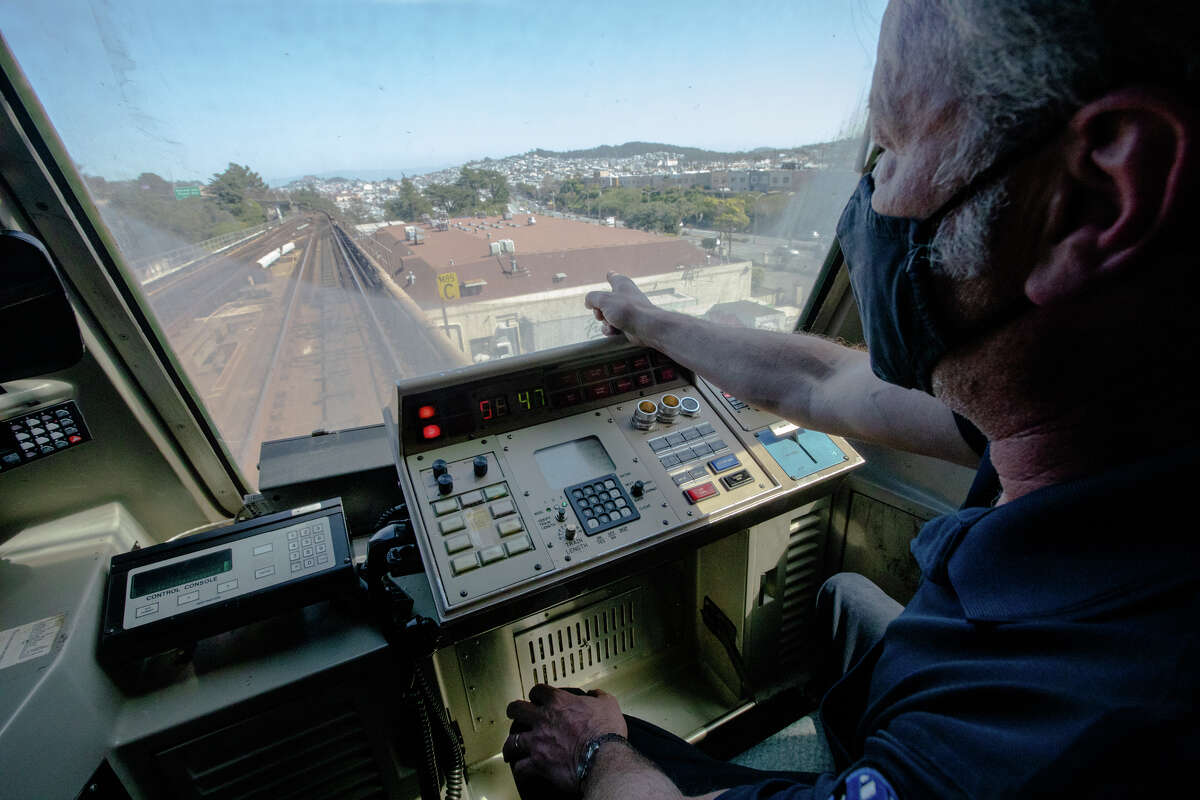El operador de trenes BART, Greg Meyer, señala uno de los letreros al costado de una vía aérea en San Francisco.