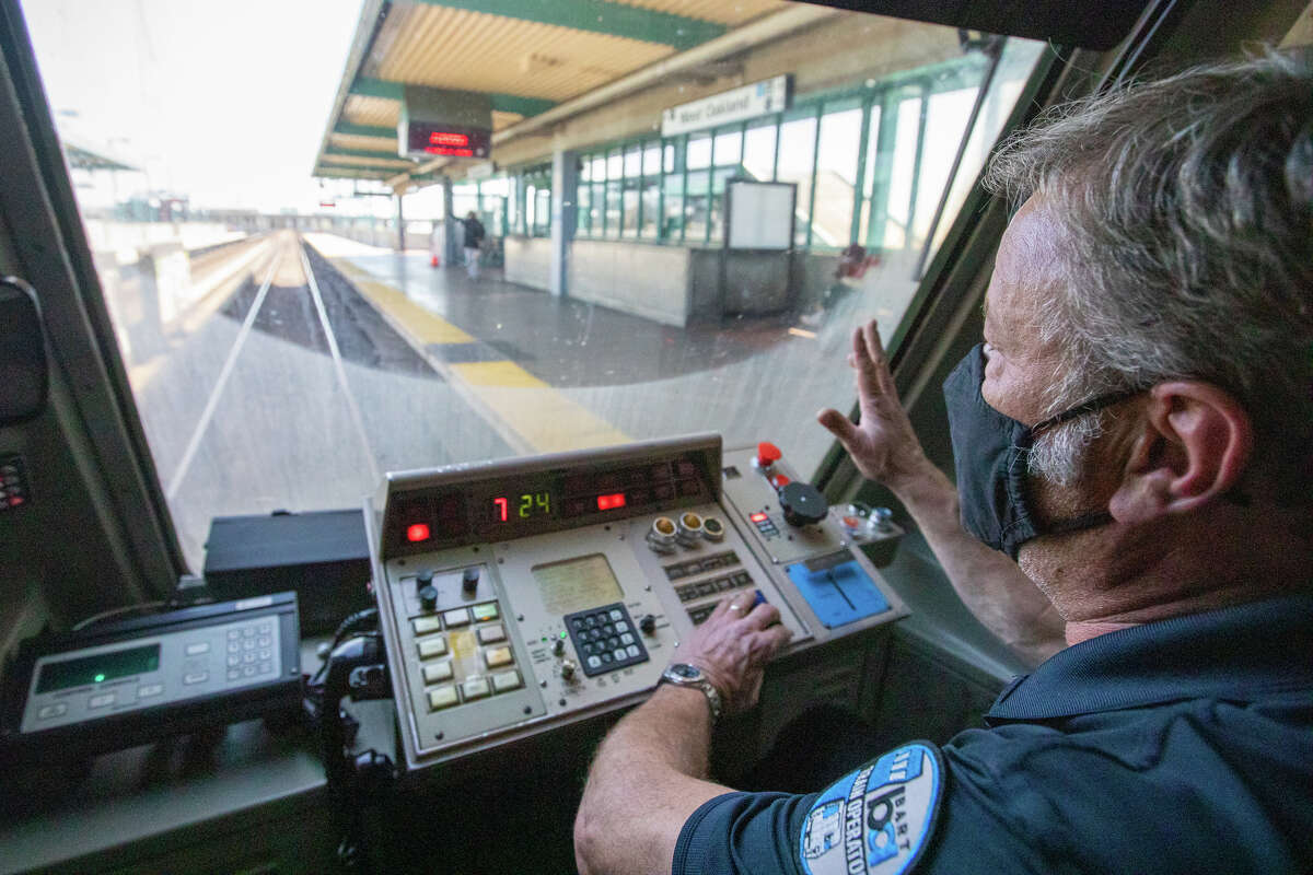 El operador del tren BART, Gray Meyer, saluda a un pasajero en una plataforma después de ingresar a la estación de West Oakland durante un viaje de SFO a Pittsburgh el 16 de marzo de 2022.