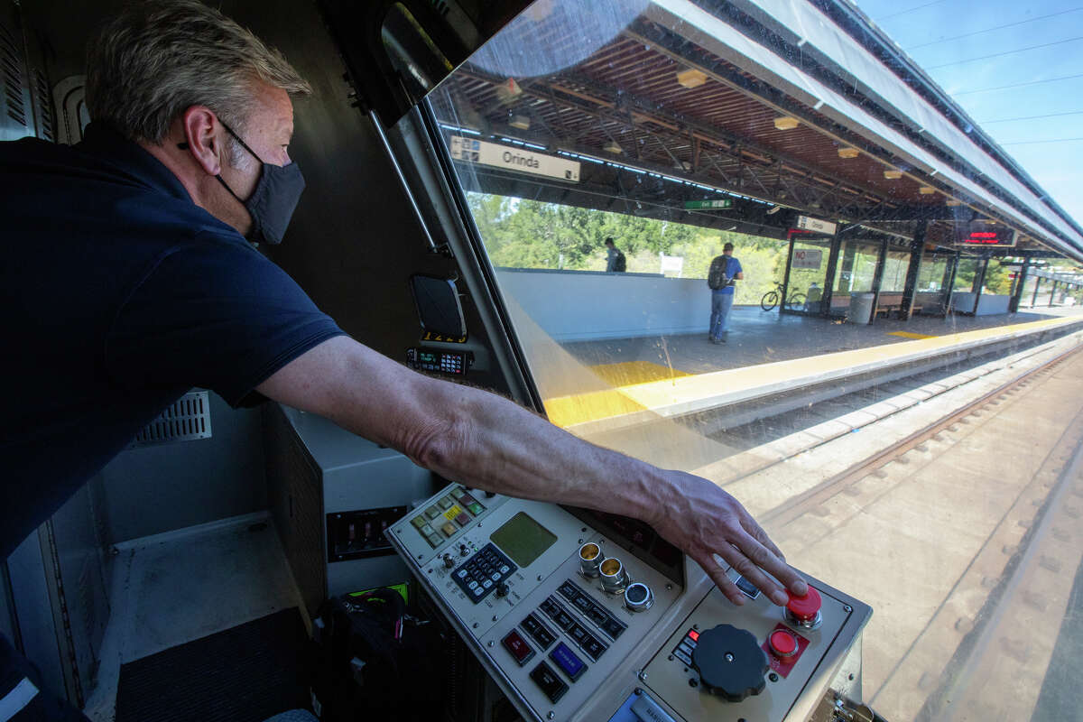El operador de trenes BART Greg Meyer mantiene su mano sobre el botón de parada cuando su tren ingresa a la estación de Orinda.