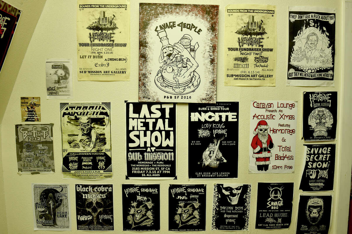 Folletos de conciertos de espectáculos anteriores se alinean en las paredes del espacio de actuación del almacén de Hemorage en Bayview. La banda produce su propia obra de arte para volantes, ropa e incluso un cómic.