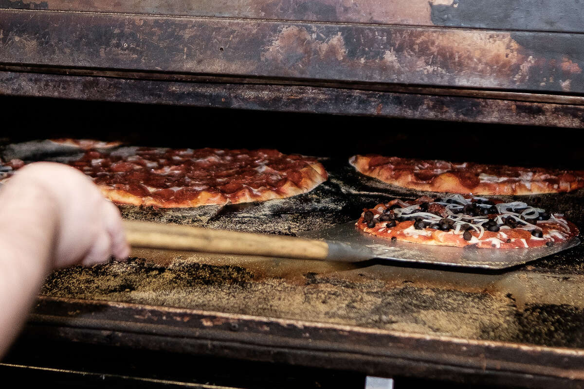 Revolviendo pizzas en un horno de pizza original de mediados de siglo, en Shakey's Pizza, en Oroville, California, el domingo 6 de marzo de 2022. 