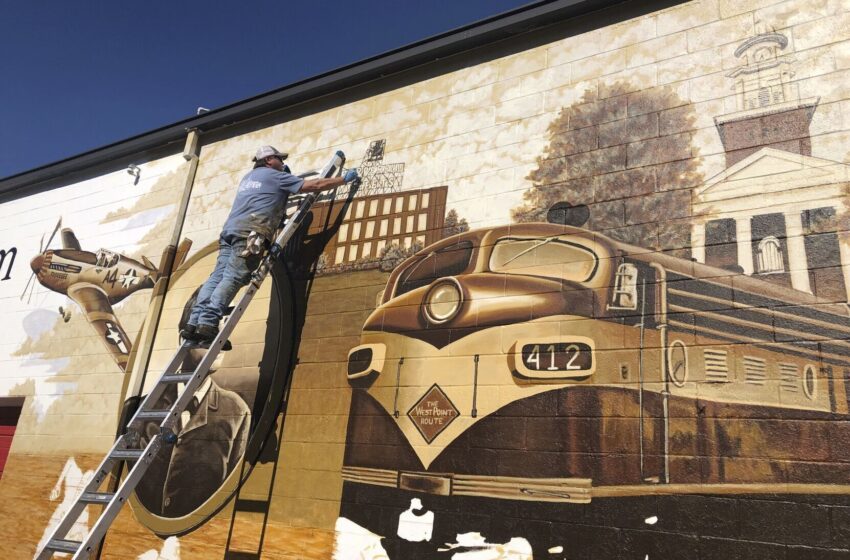  Un artista pinta un mural que cuenta la historia de Alabama del Este