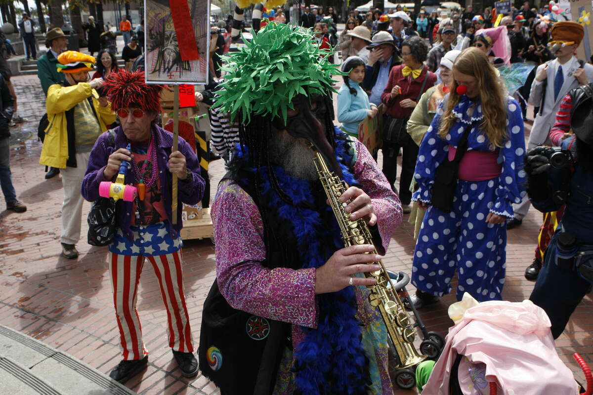 Geoff Walker, a la izquierda, de San Francisco, el hombre de la hierba, en el medio, y Kelly Moore, a la derecha, de Marin se reúnen en Justin Herman Plaza para el 35º Desfile anual del Día de San Estúpido en San Francisco el lunes 1 de abril de 2013.