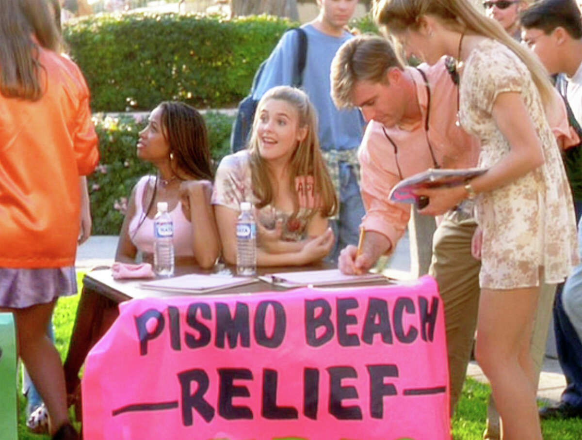 Sentadas a la mesa desde la izquierda, Stacey Dash (como Dionne) y Alicia Silverstone (como Cher) en "Clueless", escrita y dirigida por Amy Heckerling. Cher es capitana del esfuerzo de socorro en casos de desastre de Pismo Beach. 