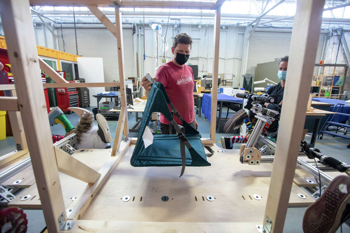 Sam Haynor habla sobre colocar un asiento para el conductor de un corredor llamado Soapbox. "Muni Toons" en el taller del Exploratorium en San Francisco el 6 de abril de 2022. El equipo participará en el Soapbox Derby en McLaren Park este domingo.