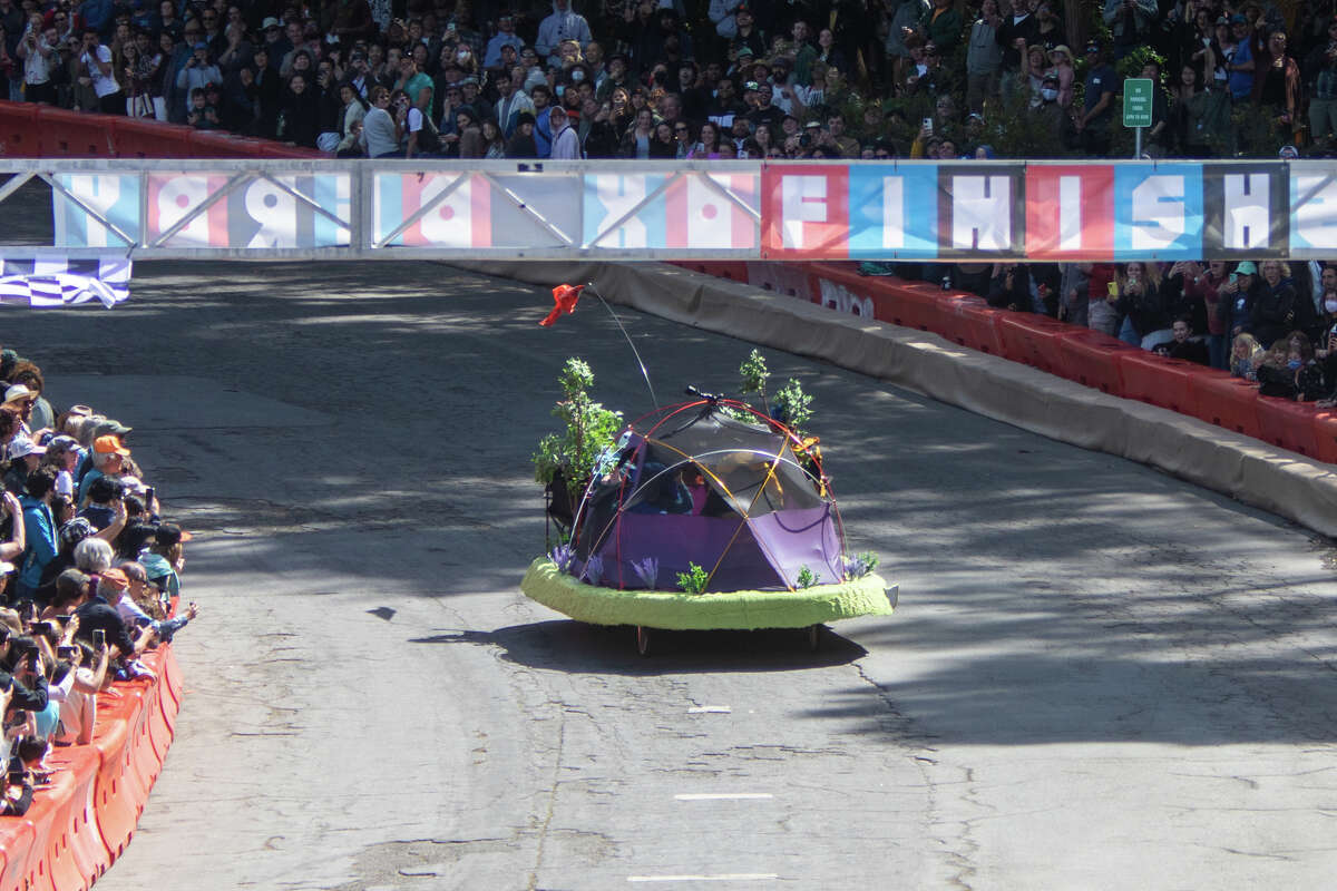 Un corredor de caja de jabón que incluye una carpa corre hasta la línea de meta en John F Shelly Drive durante el SFMOMA Soapbox Derby en McLaren Park en San Francisco, California, el 10 de abril de 2022.