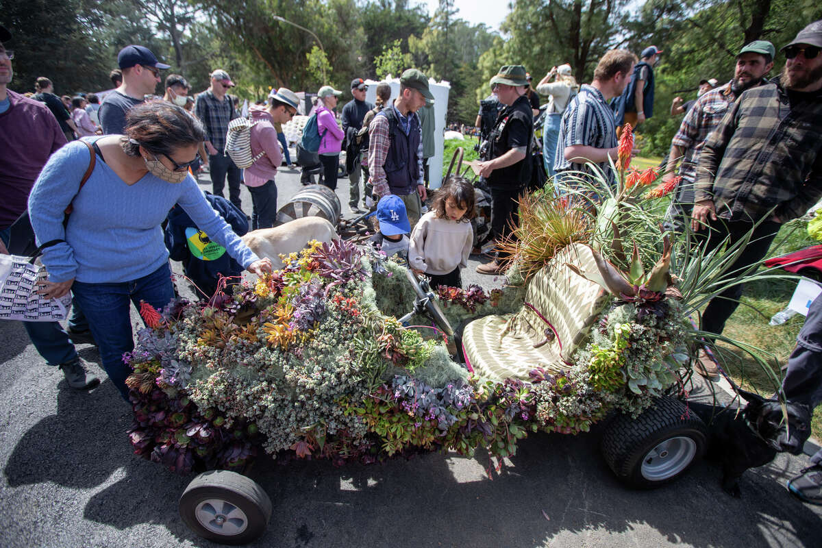 Los espectadores disfrutan y ven un corredor de caja de jabón llamado "Las suculentas de Sophie" en el foso de carreras durante el SFMOMA Soapbox Derby en McLaren Park en San Francisco, California, el 10 de abril de 2022.