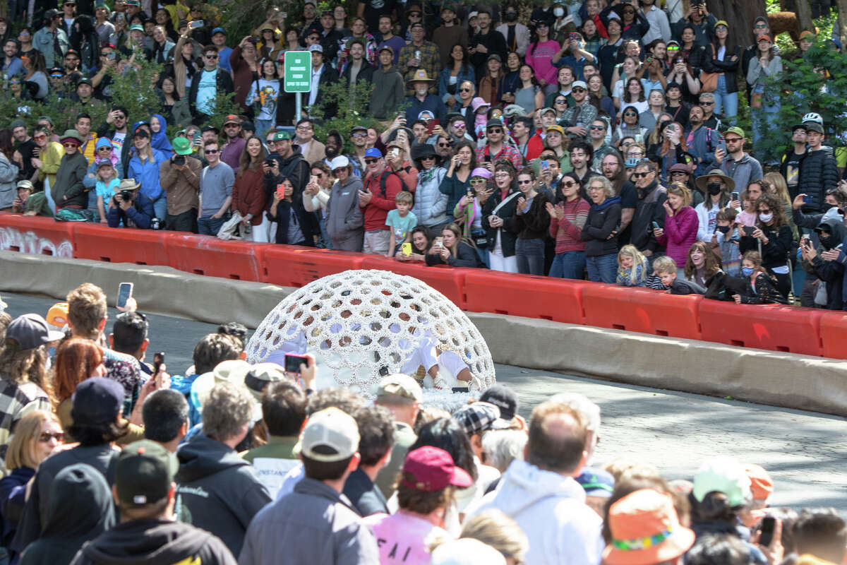 Un corredor de caja de jabón de punto llama la atención de los espectadores mientras corre cuesta abajo durante el SFMOMA Soapbox Derby en McLaren Park en San Francisco, California, el 10 de abril de 2022.