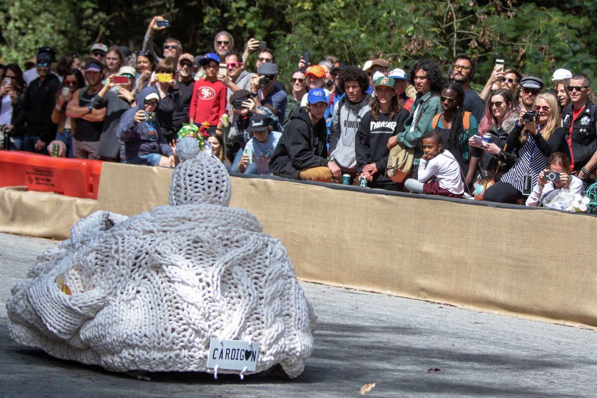 Los espectadores observan al corredor cubierto con una chaqueta de punto por John F Shelly Drive durante el SFMOMA Soapbox Derby en McLaren Park en San Francisco, California, el 10 de abril de 2022.