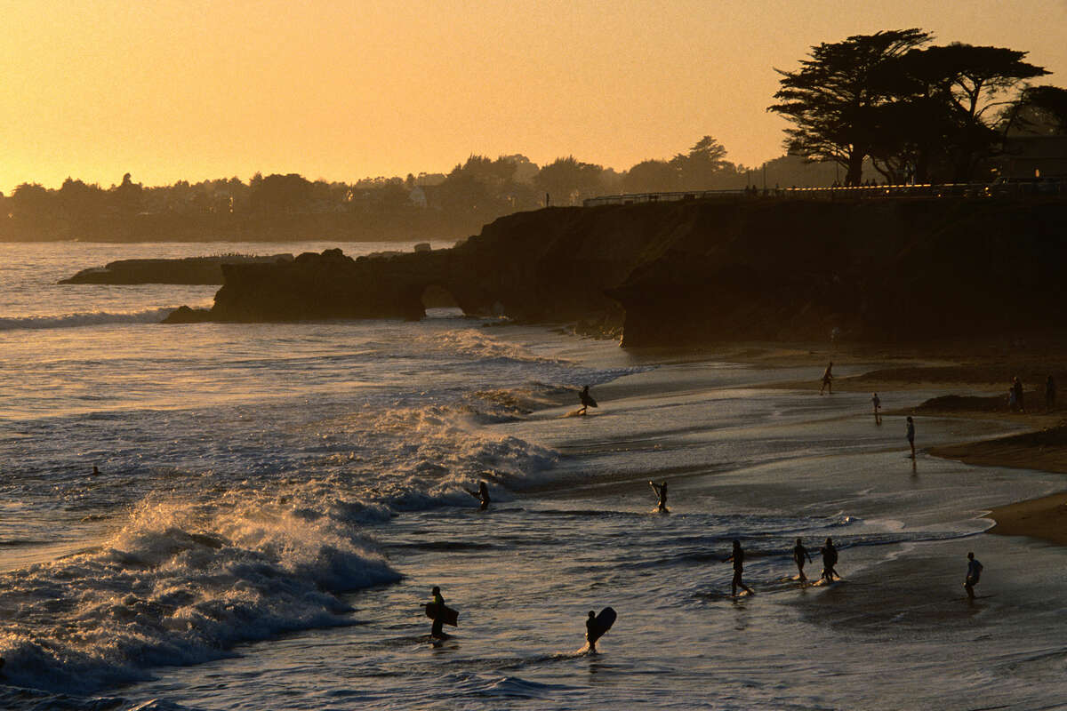 Nadadores en la playa al atardecer, en Santa Cruz, California.