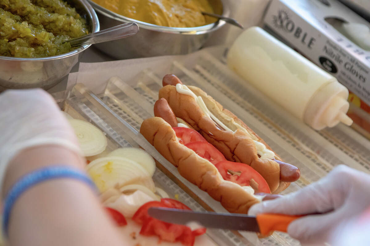La empleada de Caspers, Veronica Palomino, corta verduras mientras prepara un 'Casper Dog' en Caspers Hot Dogs en Hayward, California, el 7 de abril de 2022.