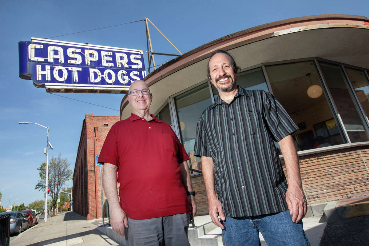 El copropietario de Caspers, Ron Dorian, a la izquierda, y el copropietario y gerente general Paul Rustigian posan para una foto afuera de la ubicación de C Street de Caspers Hot Dogs en Hayward, California, el 7 de abril de 2022.