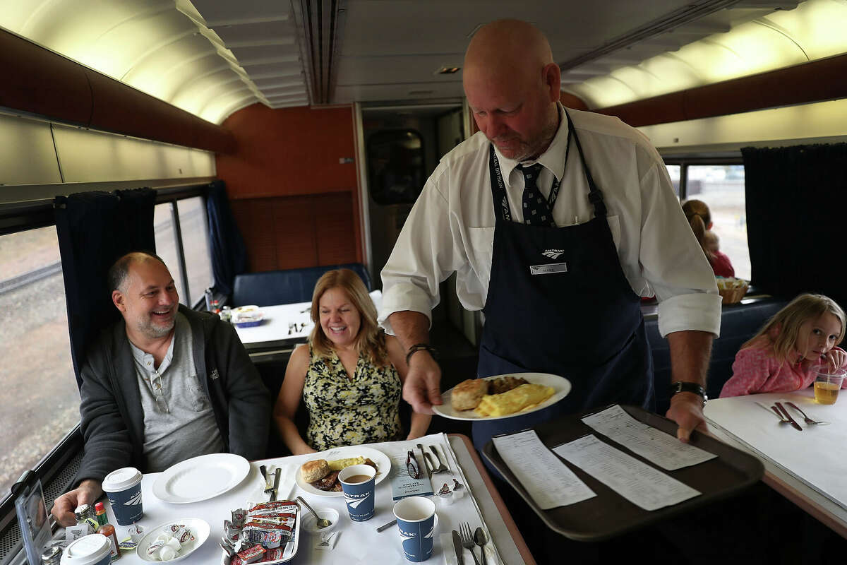 Mark Hunter sirve el desayuno a Bill Squier y Julie Blethen en el California Zephyr de Amtrak durante su viaje diario a Emeryville/San Francisco desde Chicago.