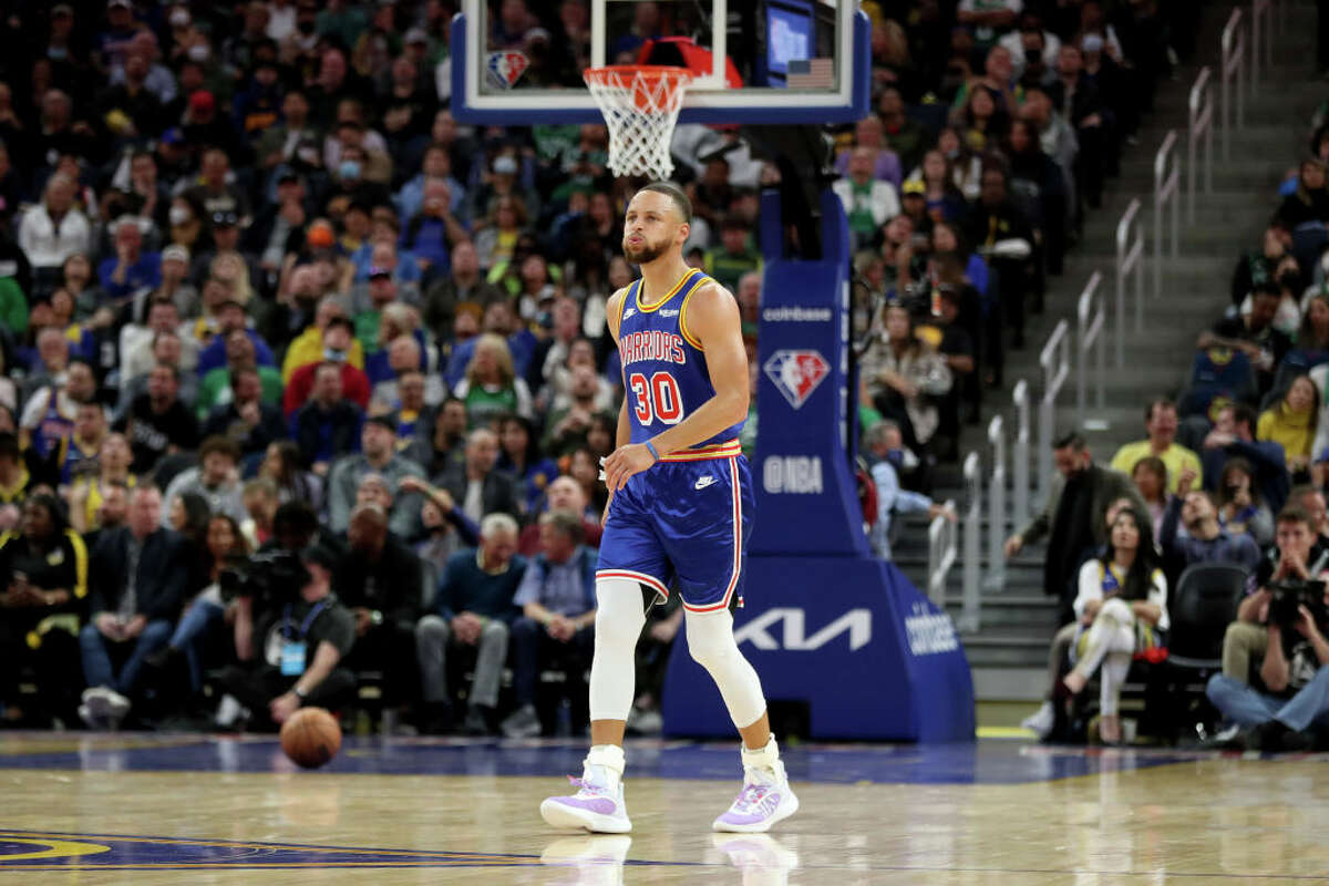 Stephen Curry de los Golden State Warriors sale cojeando de la cancha en el primer cuarto de un partido de la NBA.