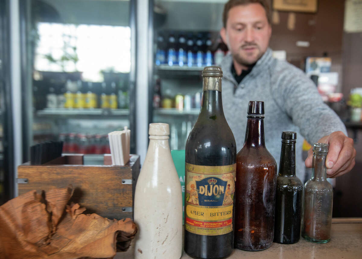 El propietario Dave Weltin muestra algunas botellas antiguas de hace más de 100 años que se encontraron en el piso del Aloha Club durante una renovación en Oakland, California, el 29 de abril de 2022.