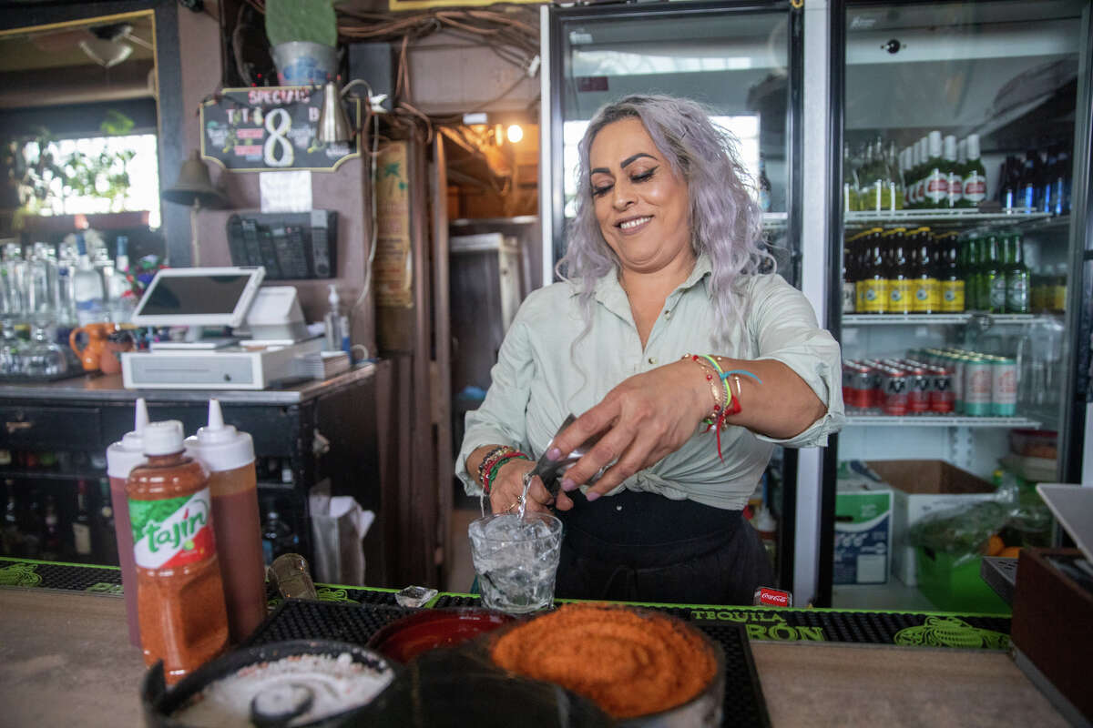 La camarera Rosa Velásquez prepara un trago detrás de la barra en el Aloha Club en Oakland, California, el 29 de abril de 2022.
