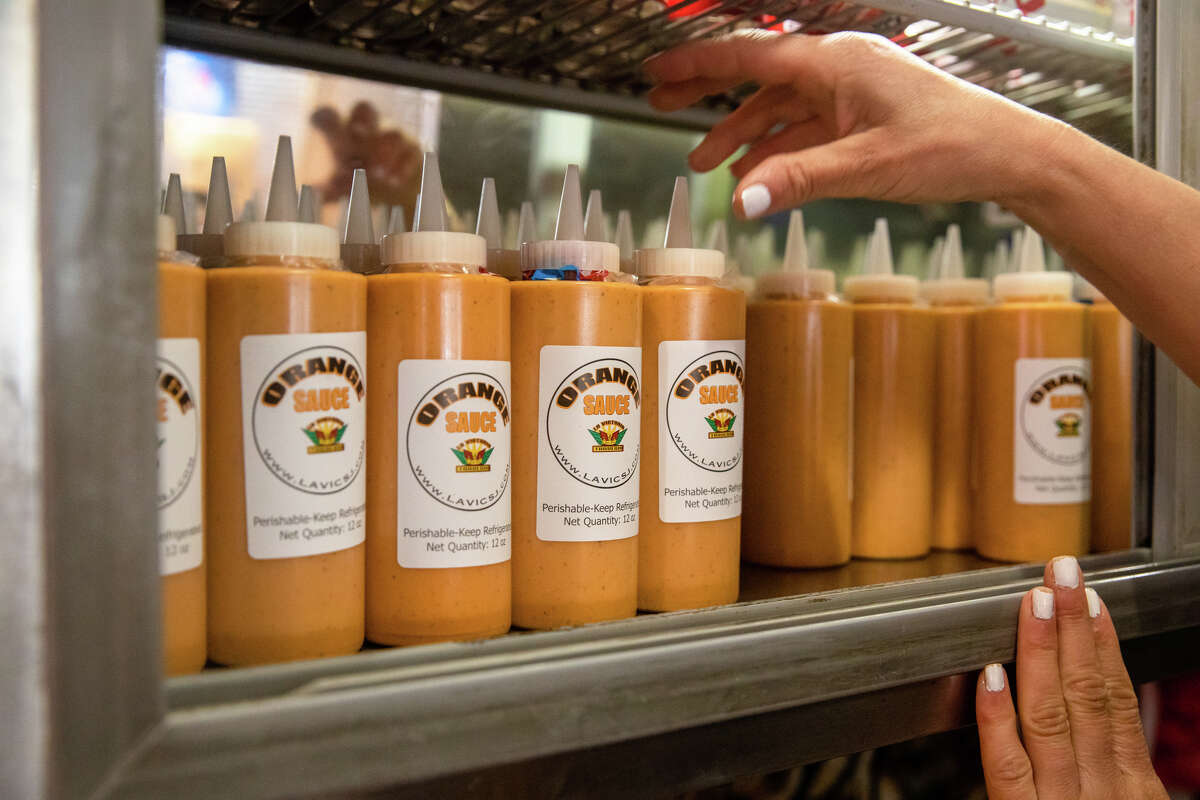 Un empleado organiza las botellas de salsa de naranja de La Victoria Taqueria disponibles para la venta en su restaurante en San José, California, el 10 de mayo de 2022.
