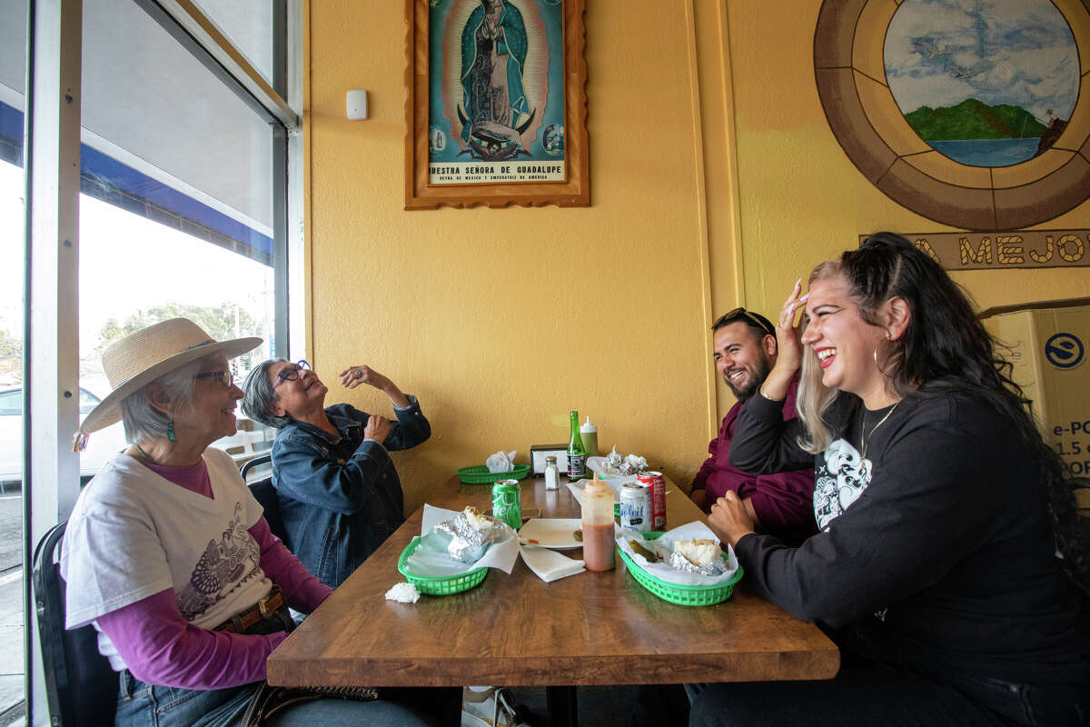 De izquierda a derecha, Irene Pérez, Catalina Govea, Esai Salas y Cecilia Peña-Govea se ríen mientras se reúnen para comer en Taqueria La Mejor en Oakland, California, el 5 de mayo de 2022.