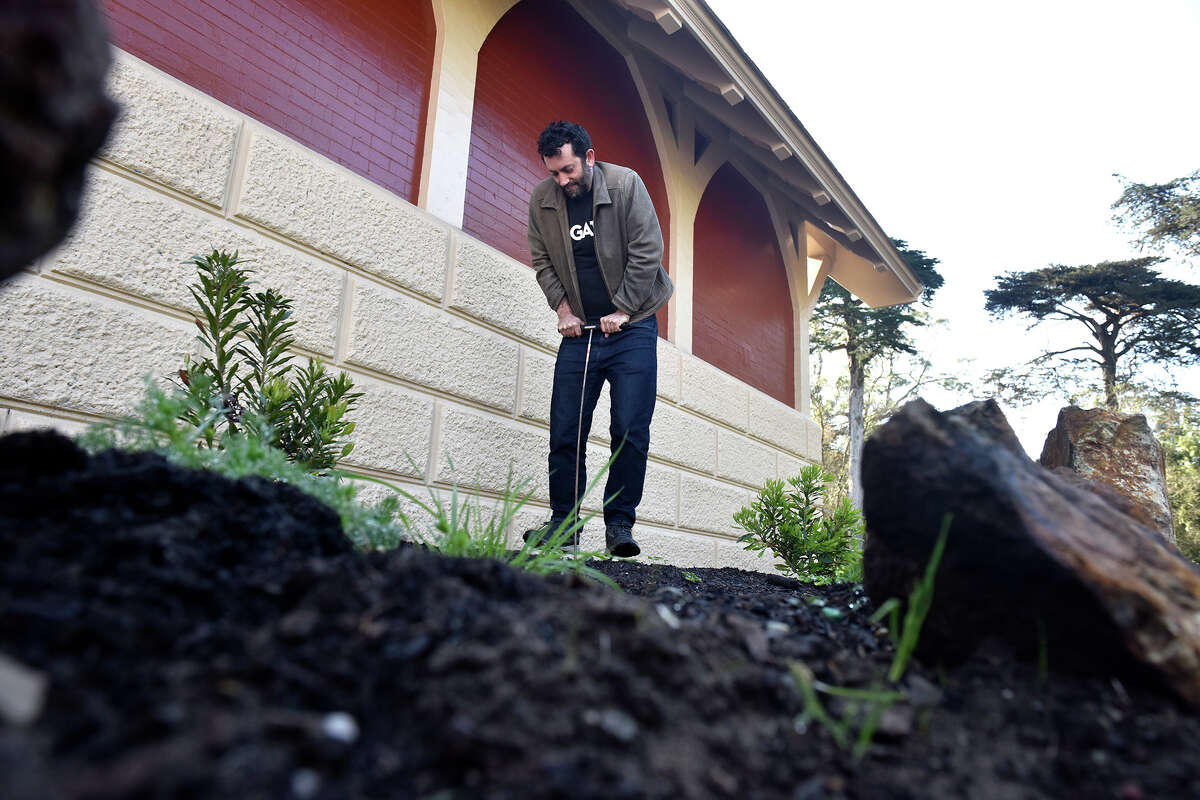 El editor de cultura de SFGATE, Dan Gentile, usa una varilla de sondeo antes de su excavación en busca de un tesoro enterrado en el Golden Gate Park, junto al refugio ferroviario de Powell Street, el viernes 15 de abril de 2022.