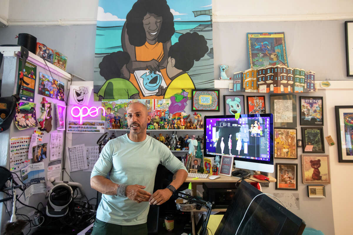 El muralista Sirron Norris muestra algunos de los dibujos del diseñador de personajes Jay Howell que ayudó a colorear y animar para el episodio piloto de "hamburguesas de bob" en el espacio de trabajo de su estudio de arte en San Francisco, California, el 3 de mayo de 2022.