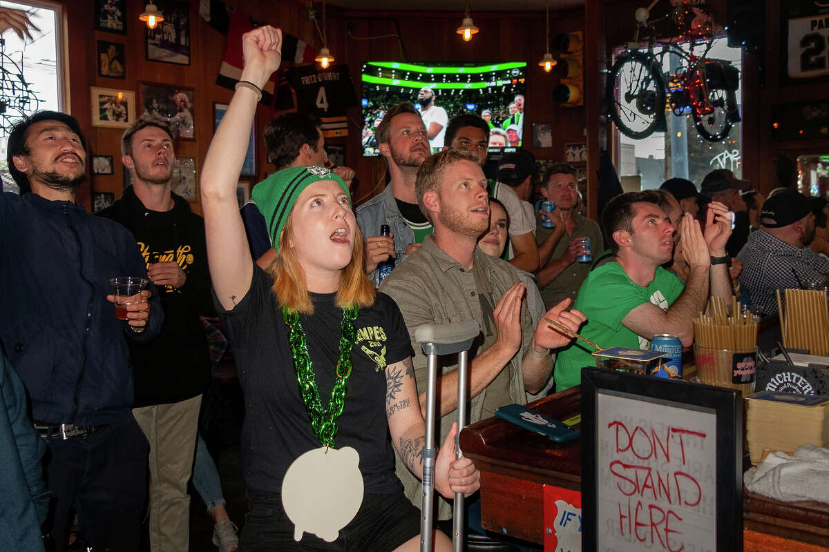 La camarera Kelly Howe, a la izquierda, actualmente en la lista de lesionados de los Yankees de Connecticut, reacciona con los fanáticos de los Celtics en el histórico bar de San Francisco Boston durante los últimos segundos de la victoria de los Celtics sobre los Warriors el 8 de junio de 2022. 