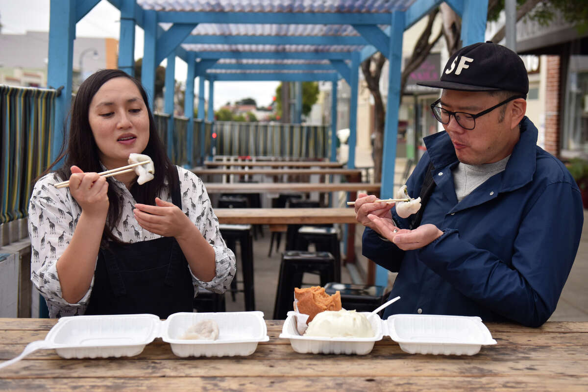 La columnista de dumplings de SFGATE, Margot Seeto, prueba algunas ofertas de Chase Luck Bakery con su amigo (y traductor de cantonés) Samson Lee, dentro del parklet Ocean Ale House, el jueves 26 de mayo de 2022.