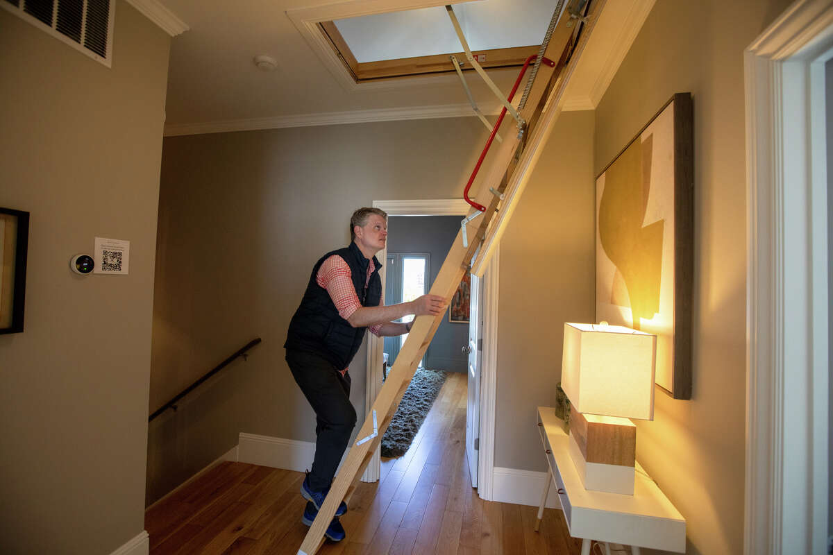 El columnista de SFGATE Drew Magary sube una escalera para ver un ático en 231 12th Ave., una casa en venta en San Francisco el 24 de mayo de 2022. Está inspeccionando el estado del mercado inmobiliario en San Francisco.