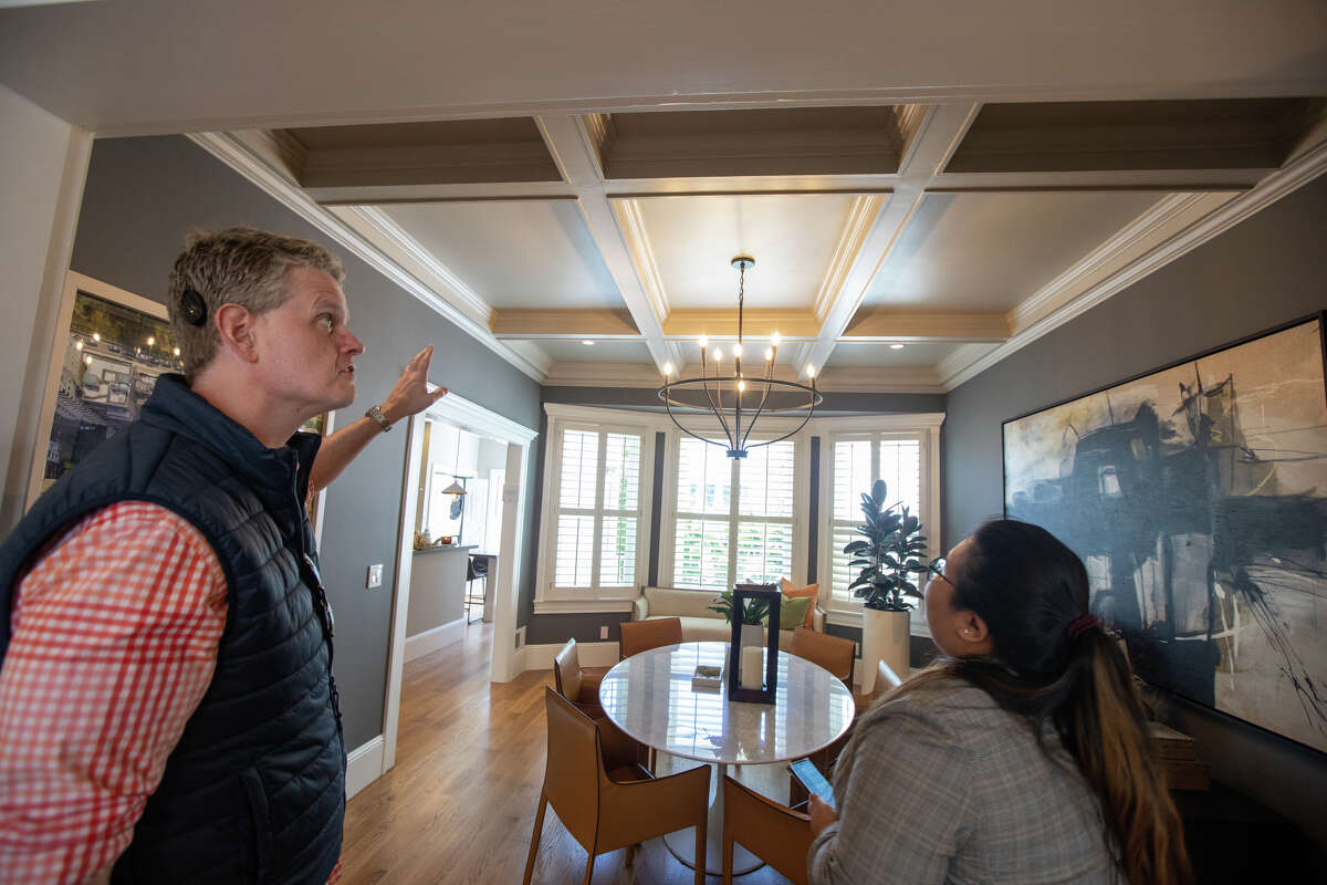 El columnista de SFGATE Drew Magary (izquierda) inspecciona el techo en 231 12th Avenue, una casa en venta en San Francisco, California, el 24 de mayo de 2022. Está inspeccionando el estado del mercado inmobiliario en San Francisco.