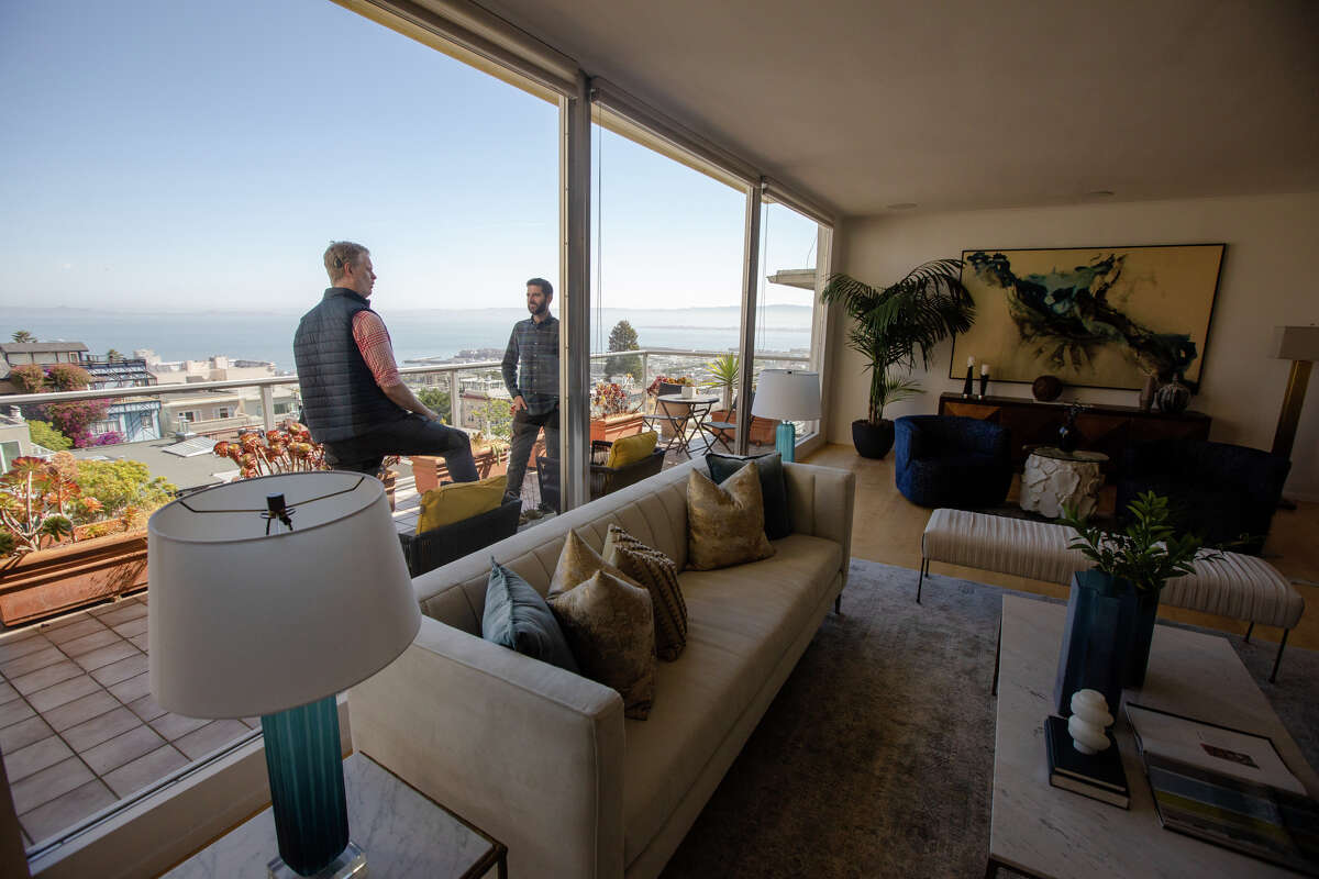 El columnista de SFGATE Drew Magary, a la izquierda, es mostrado por el agente de bienes raíces Paul Hatvany Kitchen en el condominio 1160 Greenwich St., No. 300, que está a la venta en San Francisco el 24 de mayo de 2022. Magary está inspeccionando el estado de los bienes raíces mercado en San Francisco.