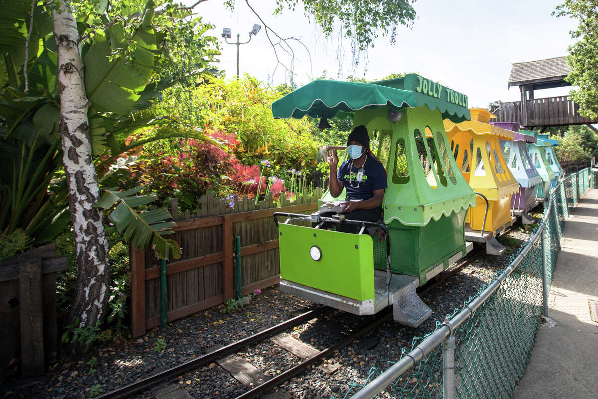 Un empleado del parque prueba el Jolly Trolly en Children's Fairyland en Oakland, California, el 8 de junio de 2022. La directora de arte y restauración Shannon Taylor y el pintor Ari Bird trabajan para restaurar y mantener las atracciones del parque temático en óptimas condiciones .