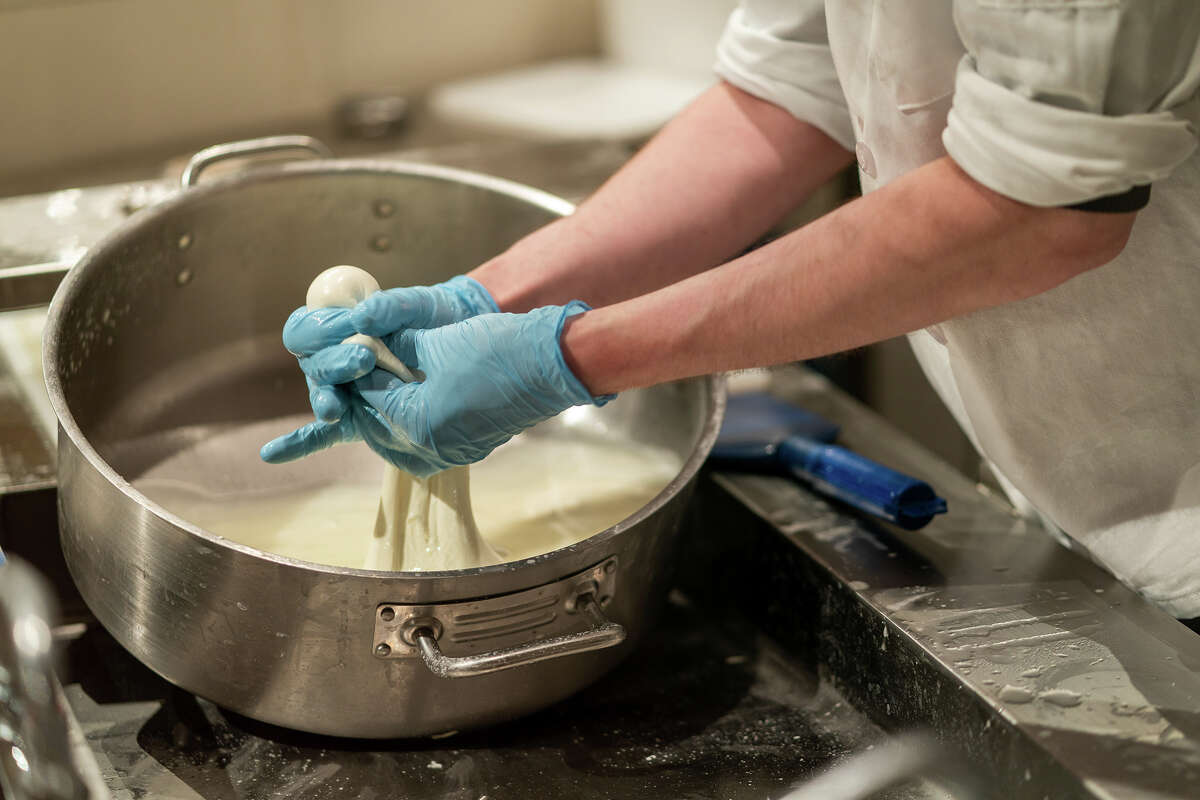 El queso mozzarella está recién preparado y empacado en una ventana para que los clientes lo vean en la sección de comestibles de Eataly en el centro comercial Westfield Valley Fair en San José el jueves 16 de junio de 2022. 