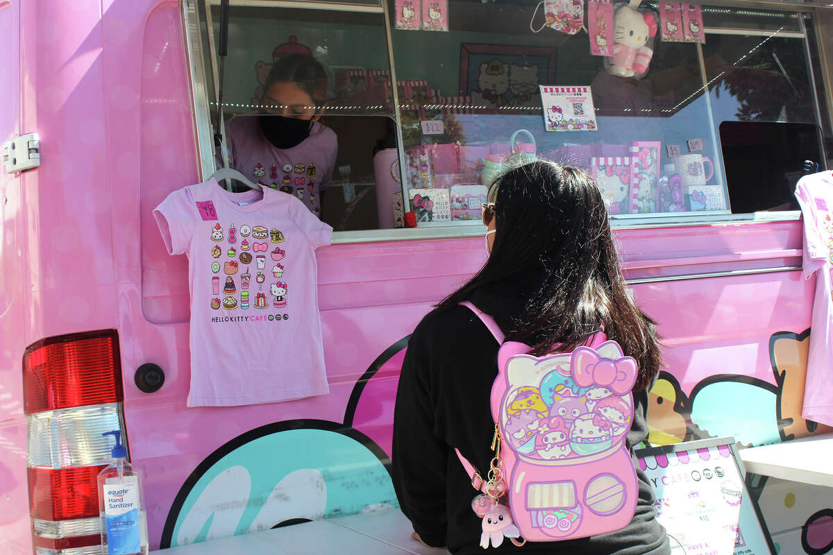 Un fanático de Hello Kitty hace un pedido en la ventana de Hello Kitty Cafe Truck con una adorable mochila de Sanrio.
