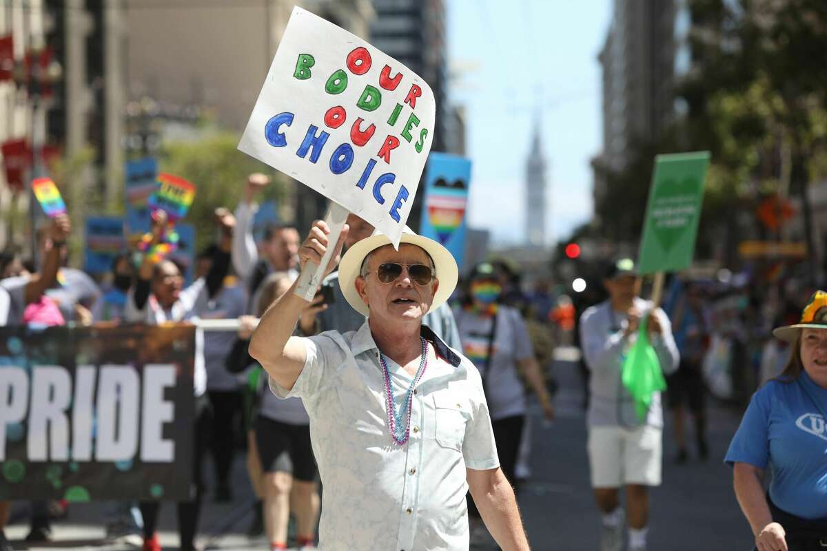 Los asistentes al Orgullo de San Francisco marchan por la ruta del desfile el 26 de junio de 2022.