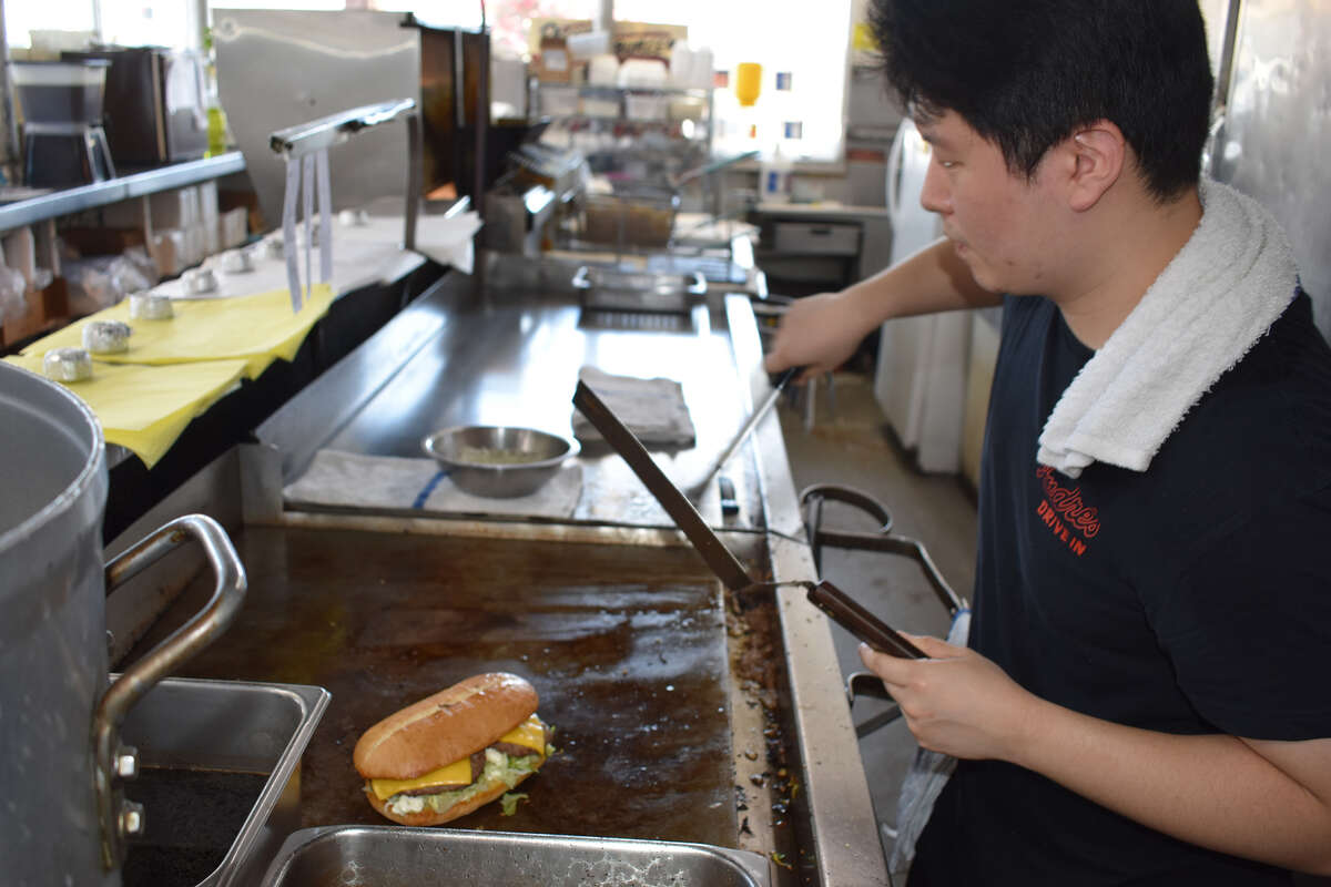 Fred Oh, el único cocinero de Andre's Drive-In, asa a la parrilla algunos de los platos favoritos de la institución de 65 años en una calurosa tarde de viernes en Bakersfield. 