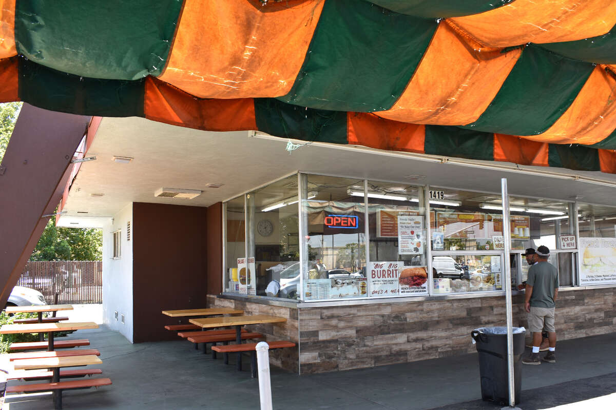 Debajo del toldo a rayas en Andre's Drive-In hay algunos lugares con sombra para disfrutar de una comida y pensar en la larga historia de una institución de comida rápida de California que todavía funciona. 