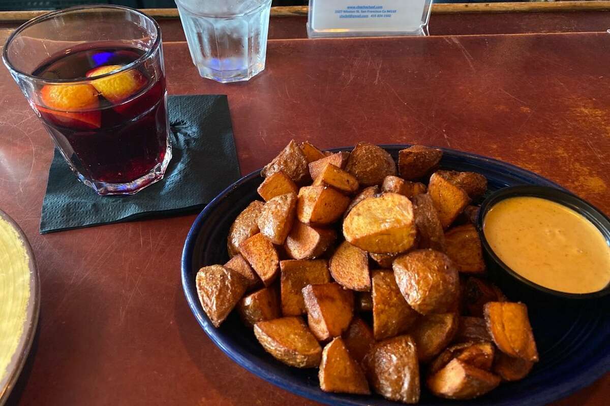 Patatas bravas crujientes en el Cha Cha Cha y una copa de sangría.